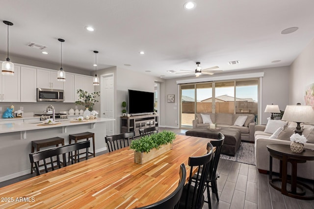 dining room with ceiling fan and sink