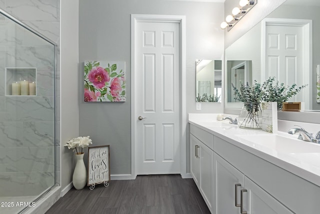 bathroom with a tile shower, wood-type flooring, and vanity