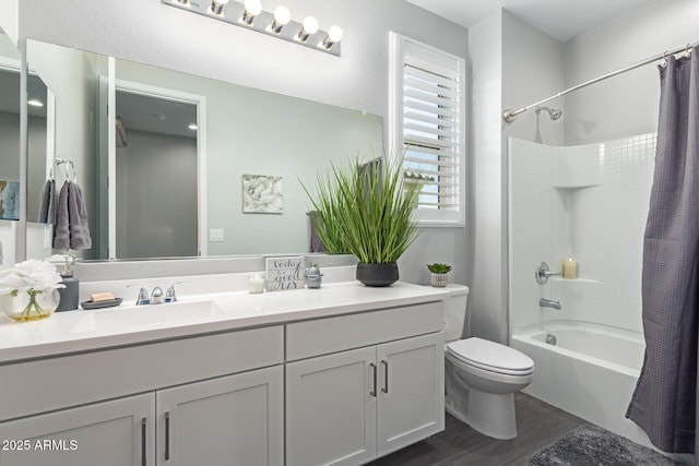 full bathroom featuring hardwood / wood-style floors, toilet, vanity, and shower / tub combo