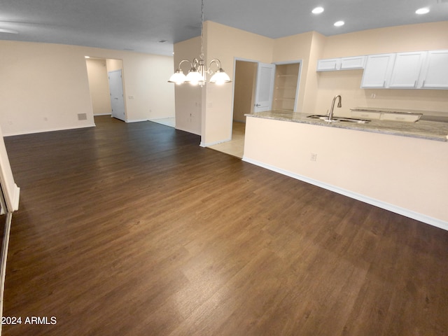 unfurnished living room featuring sink, dark wood-type flooring, and a chandelier