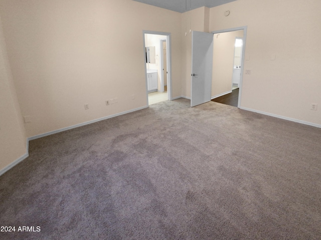 unfurnished bedroom with carpet floors and ensuite bath