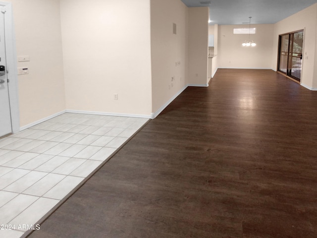 unfurnished room with light wood-type flooring and an inviting chandelier