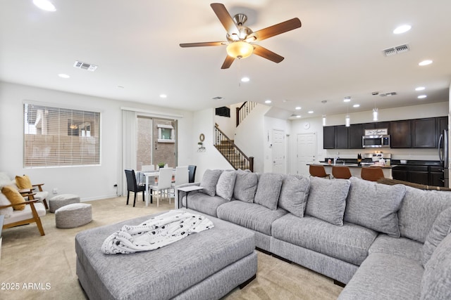 living room featuring ceiling fan and light colored carpet