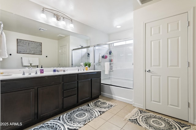 bathroom featuring enclosed tub / shower combo, tile patterned floors, and vanity