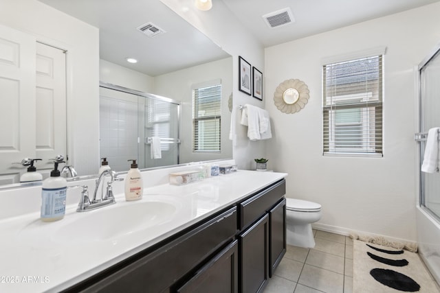 bathroom featuring toilet, vanity, tile patterned flooring, and plenty of natural light