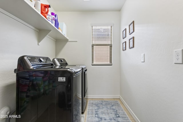 laundry area featuring washer and clothes dryer and light tile patterned floors