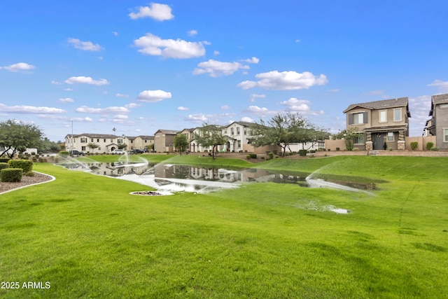 view of property's community featuring a water view and a lawn