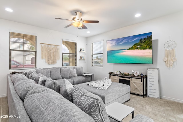 living room featuring ceiling fan, plenty of natural light, and light carpet