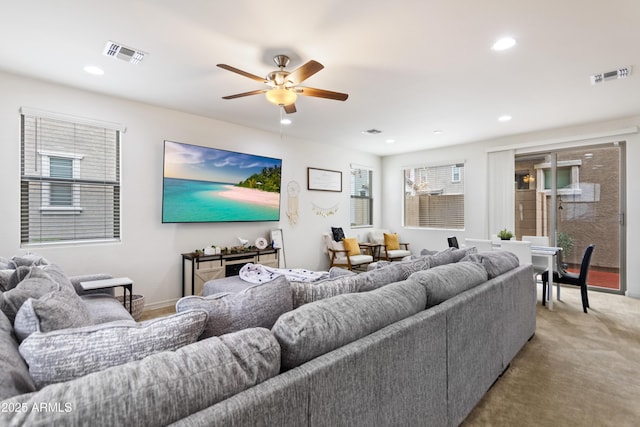 carpeted living room with ceiling fan