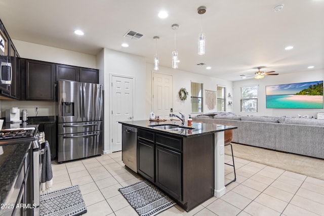 kitchen featuring ceiling fan, pendant lighting, sink, a kitchen island with sink, and stainless steel appliances