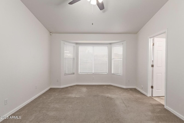 carpeted empty room featuring vaulted ceiling and ceiling fan