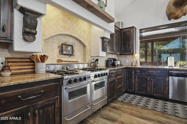 4562 N Dream Catcher Way, Pine, AZ 85544 - kitchen featuring stainless steel appliances, decorative backsplash, dark brown cabinets, wood finished floors, and light stone countertops