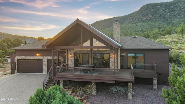 4562 N Dream Catcher Way, Pine, AZ 85544 - view of front of home with a chimney, driveway, a deck with mountain view, and stone siding