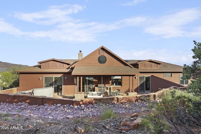 4562 N Dream Catcher Way, Pine, AZ 85544 - back of house featuring a chimney, a patio, and roof with shingles