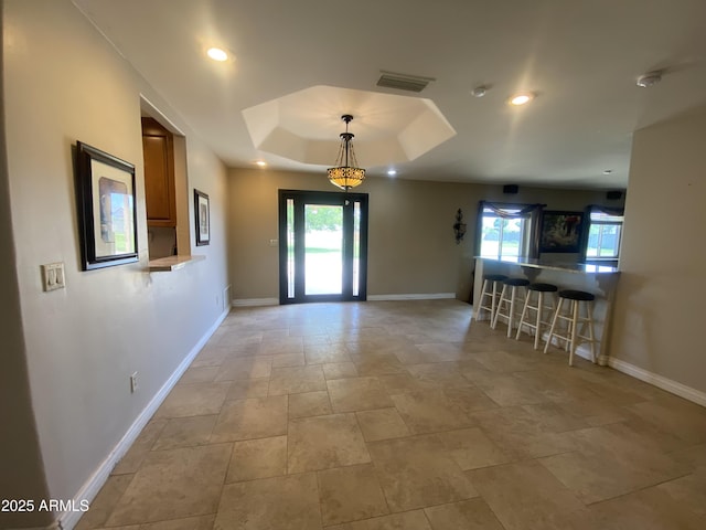 19322 E Calle De Flores, Queen Creek, AZ 85142 - unfurnished dining area with visible vents, baseboards, a raised ceiling, and stone finish floor