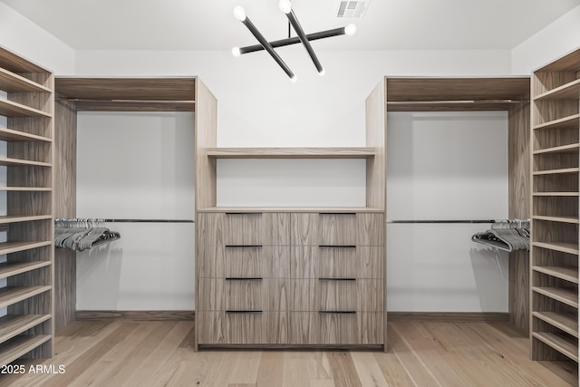 walk in closet featuring light wood-type flooring and visible vents