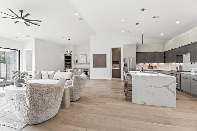 kitchen featuring lofted ceiling, ceiling fan, stainless steel appliances, and modern cabinets