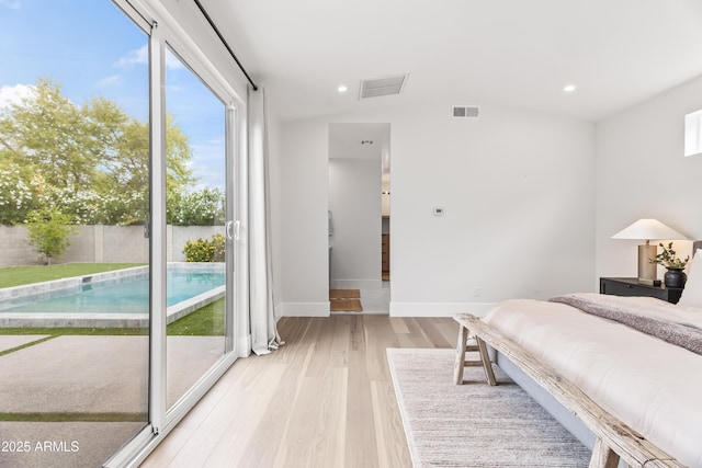 bedroom featuring baseboards, lofted ceiling, visible vents, and light wood-type flooring