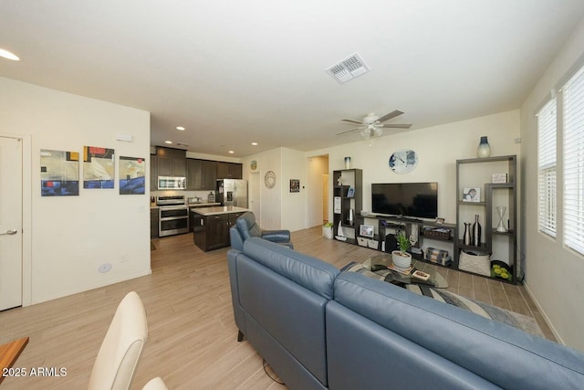 living room with ceiling fan and light wood-type flooring