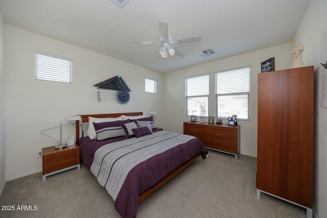 carpeted bedroom featuring multiple windows and ceiling fan