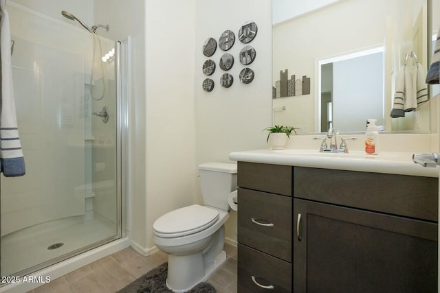 bathroom featuring hardwood / wood-style flooring, vanity, toilet, and a shower with shower door