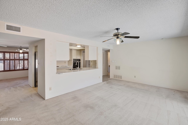 8326 E Valley View Rd, Scottsdale, AZ 85250 - unfurnished living room featuring ceiling fan, light colored carpet, a textured ceiling, and a sink