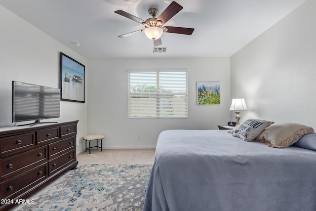 bedroom with light carpet, baseboards, visible vents, and a ceiling fan