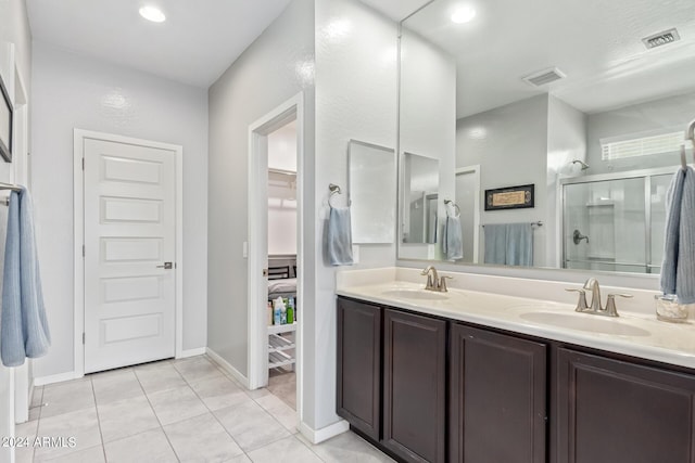 bathroom featuring a stall shower, a sink, and visible vents