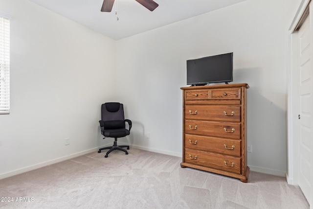 sitting room with baseboards, a wealth of natural light, a ceiling fan, and light colored carpet