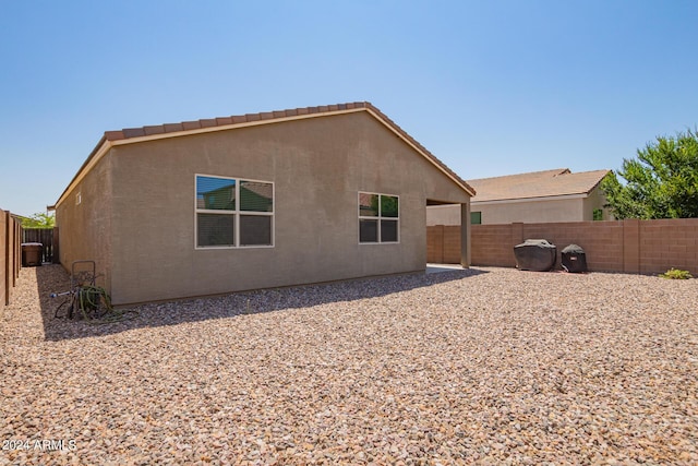 rear view of house with a fenced backyard and stucco siding