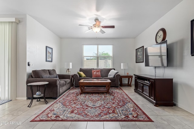 living room with baseboards, a ceiling fan, and light tile patterned flooring