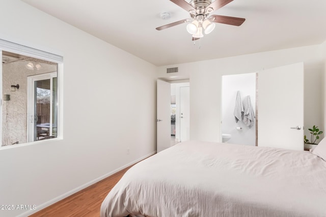 bedroom with baseboards, visible vents, connected bathroom, ceiling fan, and wood finished floors