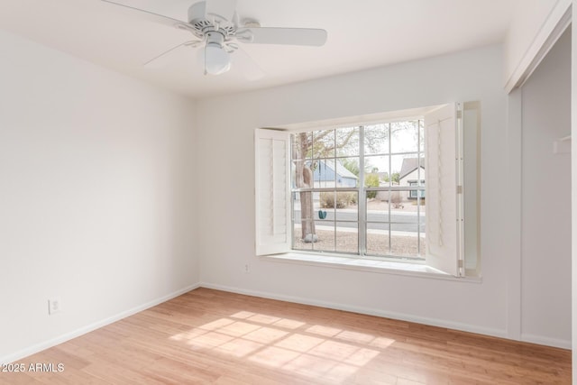 unfurnished room with a ceiling fan, light wood-style flooring, and baseboards