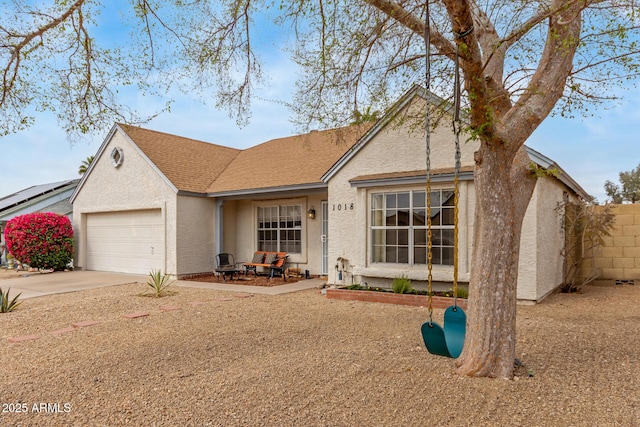 single story home featuring a garage, a shingled roof, concrete driveway, and stucco siding