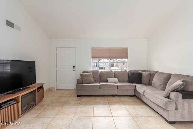 living area featuring visible vents, vaulted ceiling, and light tile patterned flooring