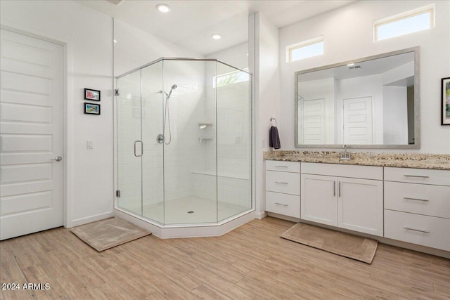 bathroom with vanity, hardwood / wood-style flooring, and a shower with shower door