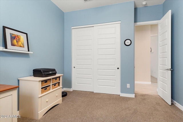 bedroom with light carpet and a closet