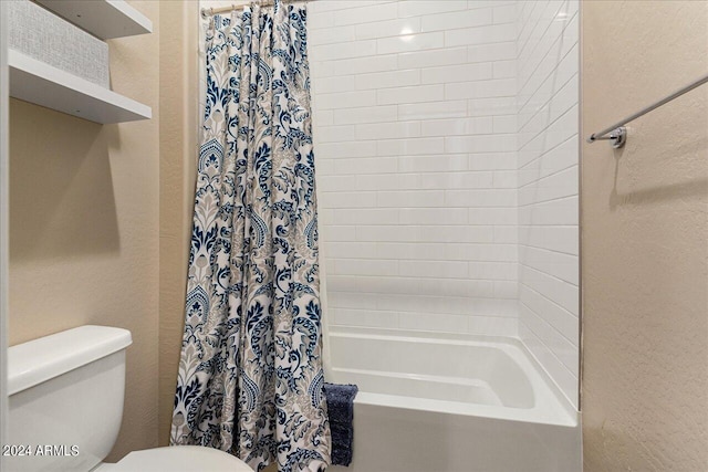 bathroom featuring shower / bath combination with curtain and toilet