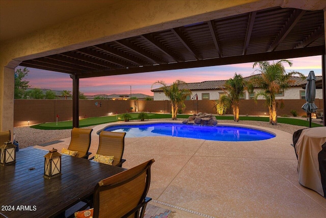 pool at dusk with a patio