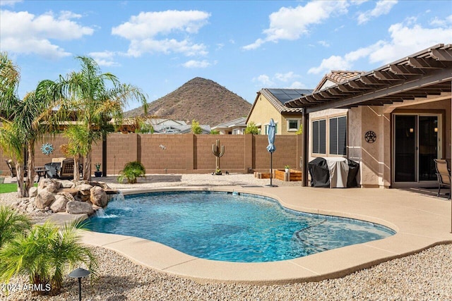 view of swimming pool with pool water feature and a patio