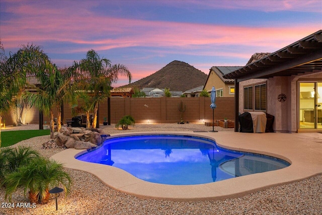 pool at dusk featuring a patio