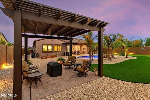 patio terrace at dusk with a fenced in pool and a pergola