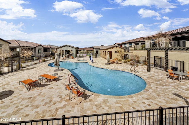 pool with a residential view, fence, and a patio