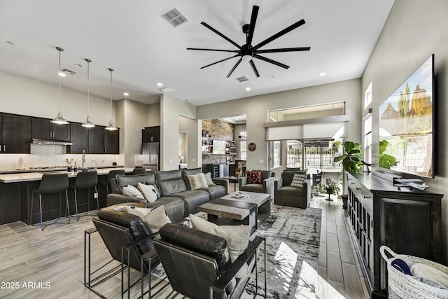 living room with light wood-style floors, recessed lighting, visible vents, and ceiling fan