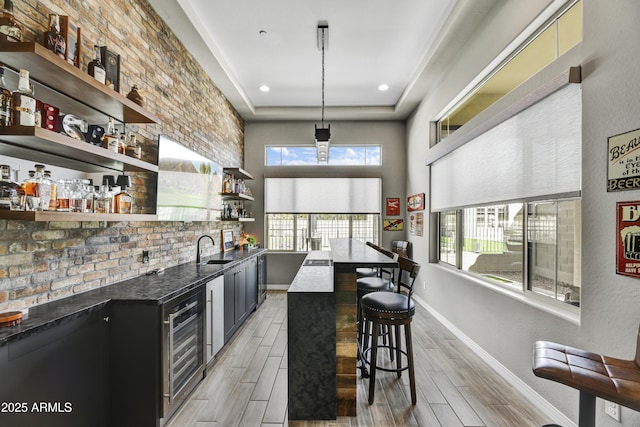 bar with wood tiled floor, wine cooler, indoor wet bar, and a sink