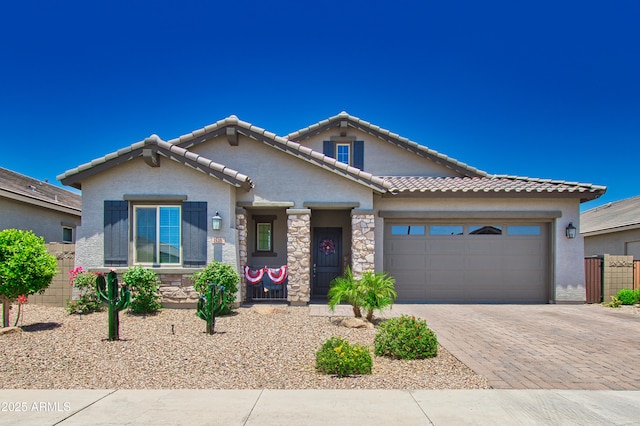 view of front of home featuring a garage, stone siding, decorative driveway, and stucco siding