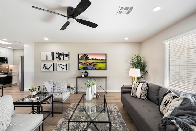 living room with hardwood / wood-style floors and ceiling fan