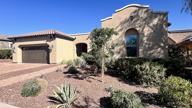 mediterranean / spanish home featuring driveway, an attached garage, and stucco siding