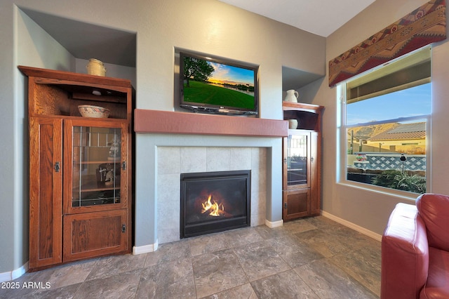 living area with a fireplace and baseboards