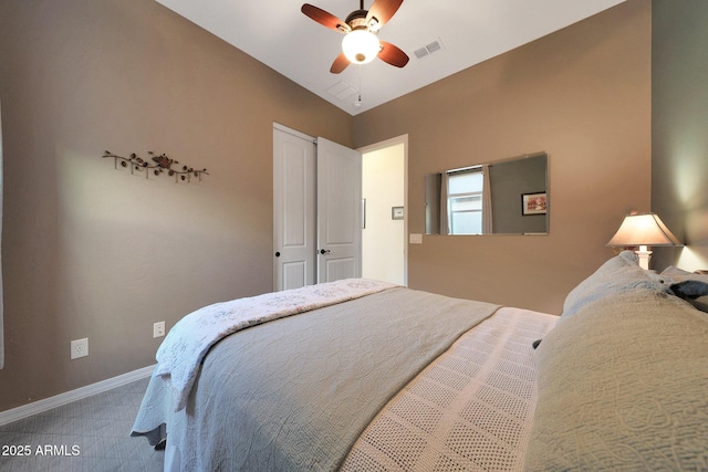 carpeted bedroom with lofted ceiling, visible vents, baseboards, and a ceiling fan